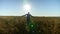 Farmer businessman with raised hands walks through the wheat field at sunrise