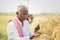 Farmer busy checking the crop yield and pests by using mobile Phone - Concept of Farmer using Smartphone technology and internet