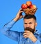 Farmer with busy face drinks apple juice and holds apples