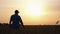 Farmer checking crops at sunset