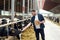 Farmer with clipboard and cows in cowshed on farm