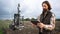 Farmer controls autonomous robot for measuring soil quality in an agricultural field.