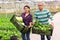 Farmer couple holding crates with lettuce and celery