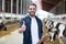 Farmer with cows showing thumbs up on dairy farm