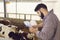 Farmer with documents doing quality monitoring in barn with calves on livestock farm