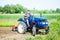 A farmer drives a tractor on a farm field. Agricultural cultivation technology equipment and technical transport. Loosening the