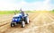 Farmer drives a tractor on a farm field. Agricultural industry. Cultivating land soil for further planting. Loosening, improving