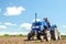 A farmer drives a tractor on a farm field. Bottom view. Loosening surface, land cultivation. Farming, agriculture