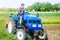 A farmer drives a tractor while working on a farm field. Loosening surface, cultivating the land. Farming, agriculture.