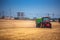 Farmer driving agricultural tractor and trailer full of grain