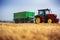 Farmer driving agricultural tractor and trailer full of grain