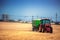 Farmer driving agricultural tractor and trailer full of grain