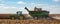 A farmer driving his John Deere tractor pulling a grain hopper