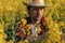 Farmer examining blooming rapeseed plant in cultivated field