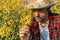 Farmer examining blooming rapeseed plant in cultivated field