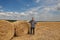 Farmer examining wheat field after harvest and gesturing