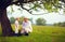 Farmer family having fun under an old tree, spring countryside