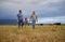 Farmer family walking on a cattle or livestock farm teaching and learning together. Generations of a happy father