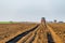 Farmer fertilizing arable land with nitrogen, phosphorus, potassium fertilizer