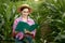 Farmer with a folder stands in a corn field and checks the growth of vegetables. Agriculture - food production, harvest concept