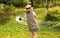 Farmer girl in summer straw hat. Little gardener farming spinning, having fun in garden with big green watering can water fresh