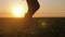 Farmer goes with rubber boots along green field. Rubber boots for work use. A worker go with his rubber boots at sunset