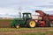 Farmer in green tractor digging and harvesting sugarbeets