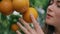 Farmer hand touching tangerines at garden close up. Woman smelling citrus fruits