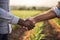 farmer handshake on agricultural field