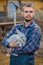 Farmer handsome european caucasian rural portrait in countryside with beard, shirt and overalls looking at camera with white