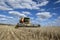 A farmer harvests a broadacre paddock of wheat.