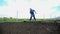 Farmer with hay hat using the rake on his garden