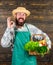 Farmer hipster straw hat deliver fresh vegetables. Fresh organic vegetables in wicker basket. Man bearded farmer wear