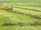 Farmer on his tractor that moves the grass to make it dry at Engelberg on the Swiss alps