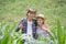 A farmer and his wife standing in their cornfield happily.
