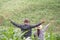 A farmer and his wife standing in their cornfield happily.