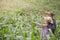 A farmer and his wife standing in their cornfield happily.