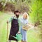 A farmer and his wife standing in their field. Farmars couple enjoy spring nature and take care about her plants. Earth