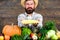 Farmer hold corncob or maize wooden background. Farmer presenting fresh vegetables. Farmer with homegrown harvest