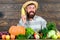 Farmer hold corncob or maize wooden background. Farmer presenting organic homegrown vegetables. Grow organic crops