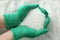 Farmer holding ammonium nitrate pellets in hands over pile, top view. Mineral fertilizer