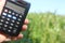 Farmer holding Calculator in hand calculate production field. Business concept