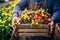 A farmer holding a crate of colorful flowers at a local farmers\\\' market, showcasing.