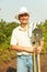 Farmer holding pitchfork and spade