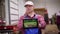 Farmer holds digital tablet in hands on background of potato storage warehouse. It shows potato field irrigation system