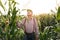 Farmer holds young corn leaves in his hand. Crop field of corn. Senior farmer checks the harvest on the field. Male hand