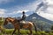 Farmer on a horse looking at the Tungurahua eruption