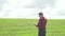Farmer inspects peas growth. Fresh green peas field. Digital tablet in man`s hand. Rear view