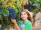 Farmer kid girl in vineyard harvest autumn leaves in mediterranean