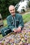 Farmer kneeling in front of box of fruits